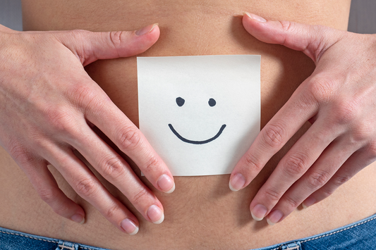 two hands on a belly holding a post it with a smiley before it