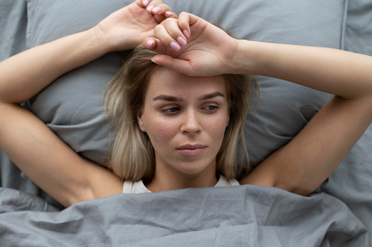 woman laying in bed looking stressed, can not fall asleep because of overthinking